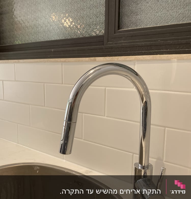 ברז כרום מעל כיור נירוסטה עם חיפוי קיר קרמיקה לבן